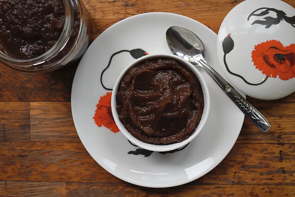 Slow Cooker Apple Butter in a dish with poppy china and jar of Apple Butter